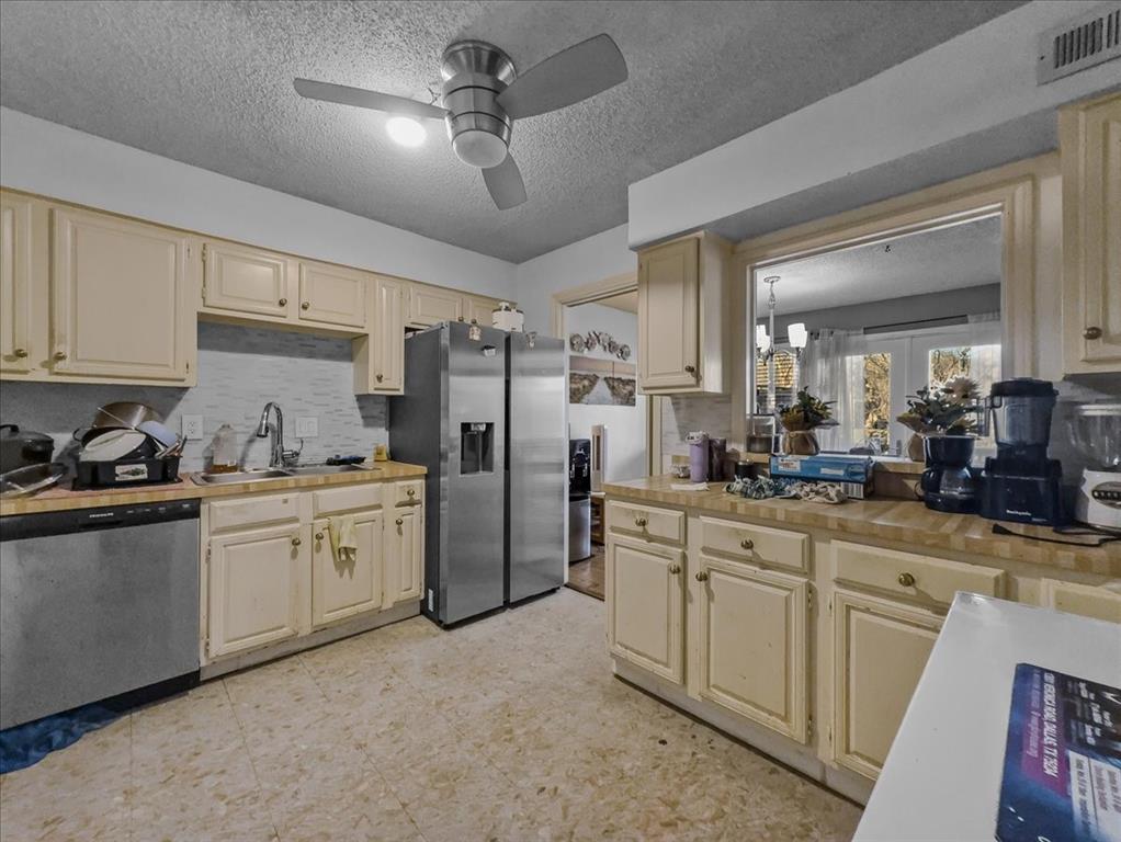8411 Oak Streme Dallas, TX 75243 - Photo 12 of 28 a kitchen with refrigerator and cabinets