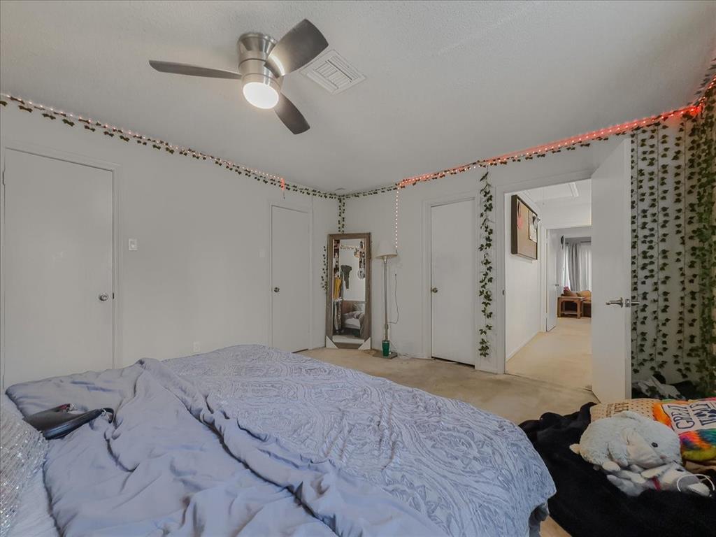 8411 Oak Streme Dallas, TX 75243 - Photo 16 of 28 a bedroom with bed and a chandelier