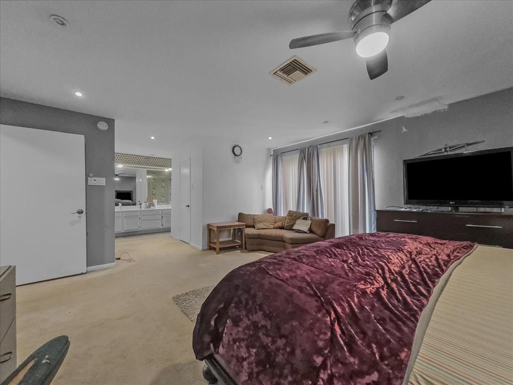 8411 Oak Streme Dallas, TX 75243 - Photo 19 of 28 a spacious bedroom with a bed and a flat screen tv