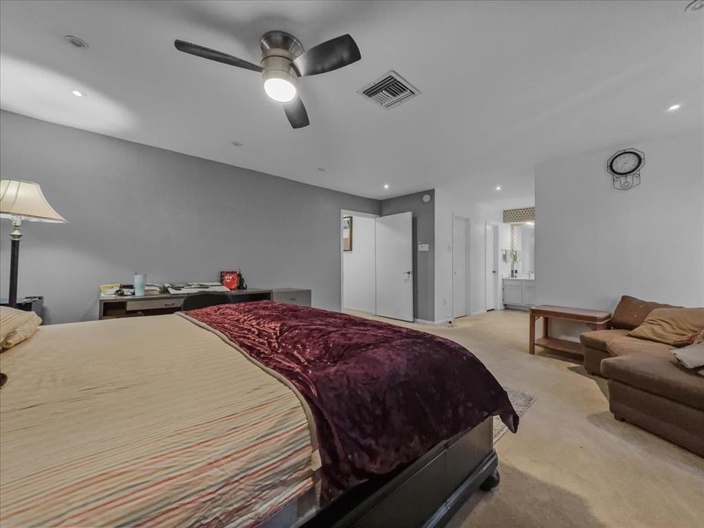 8411 Oak Streme Dallas, TX 75243 - Photo 22 of 28 a spacious bedroom with a bed and ceiling fan