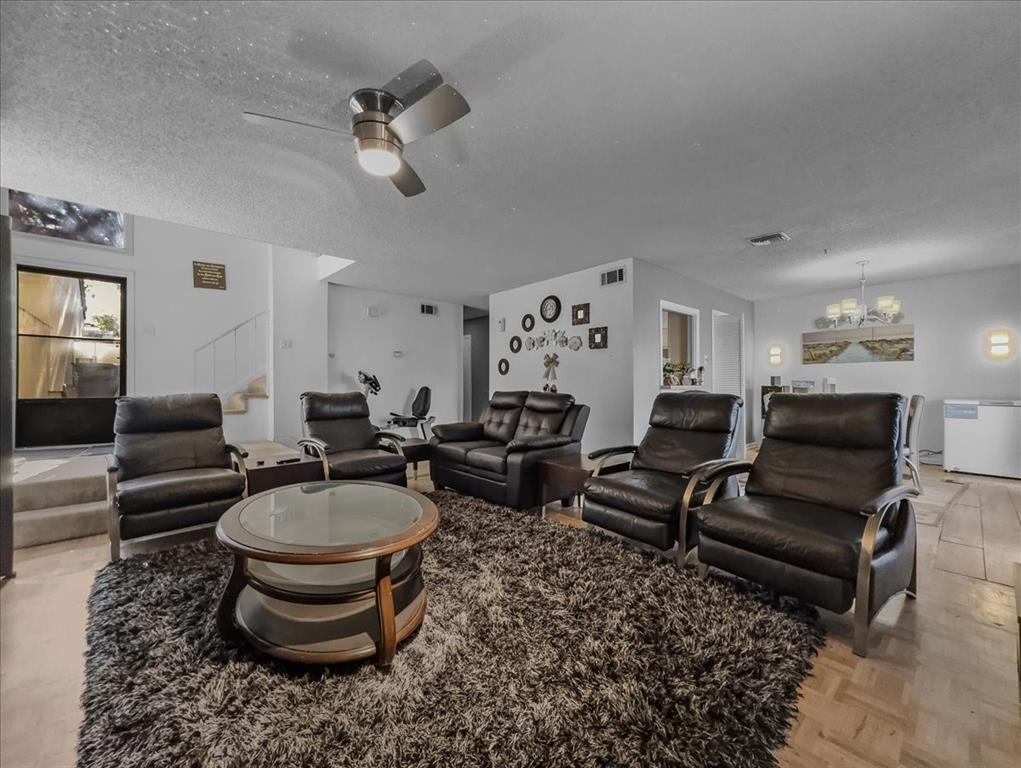 8411 Oak Streme Dallas, TX 75243 - Photo 7 of 28 a living room with furniture a rug and a chandelier