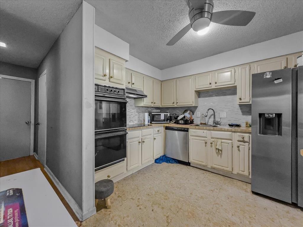 8411 Oak Streme Dallas, TX 75243 - Photo 10 of 28 a kitchen with granite countertop white cabinets and stainless steel appliances