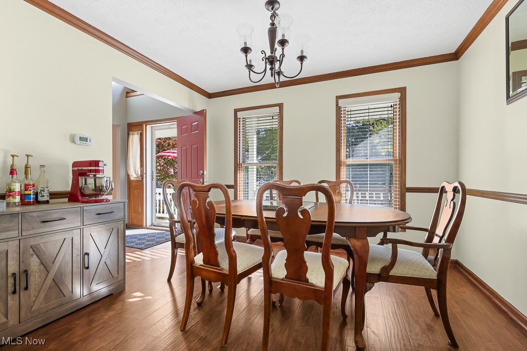 3982 Baird Road Stow, OH 44224 - Photo 6 of 50 Dining room with a chandelier, crown molding, and dark wood-style flooring