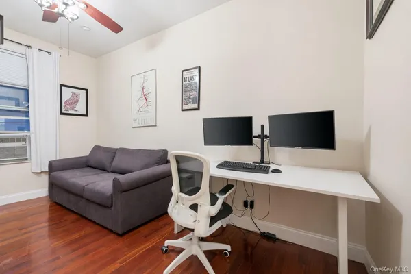 a living room with furniture a flat screen tv and a refrigerator