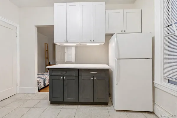 a kitchen with a refrigerator and white cabinets