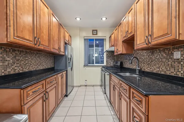 a kitchen with stainless steel appliances granite countertop a stove a sink a microwave and a dining table