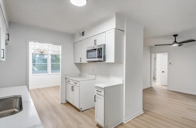 a view of a kitchen with wooden floor and a sink