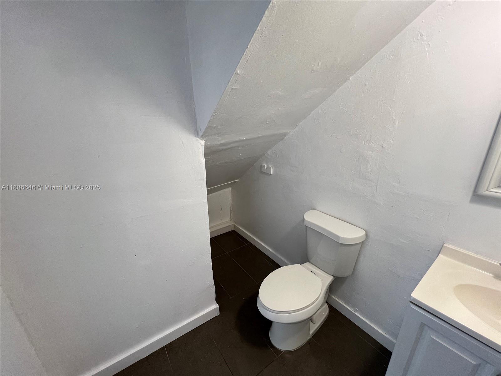 548 Northwest 30th Street, Unit 2 Miami, FL 33127 - Photo 6 of 12 a white toilet sitting next to a white sink and vanity