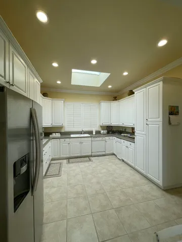 a large kitchen with stainless steel appliances lots of white cabinets