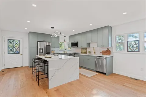 a living room with furniture a wooden floor and a sink