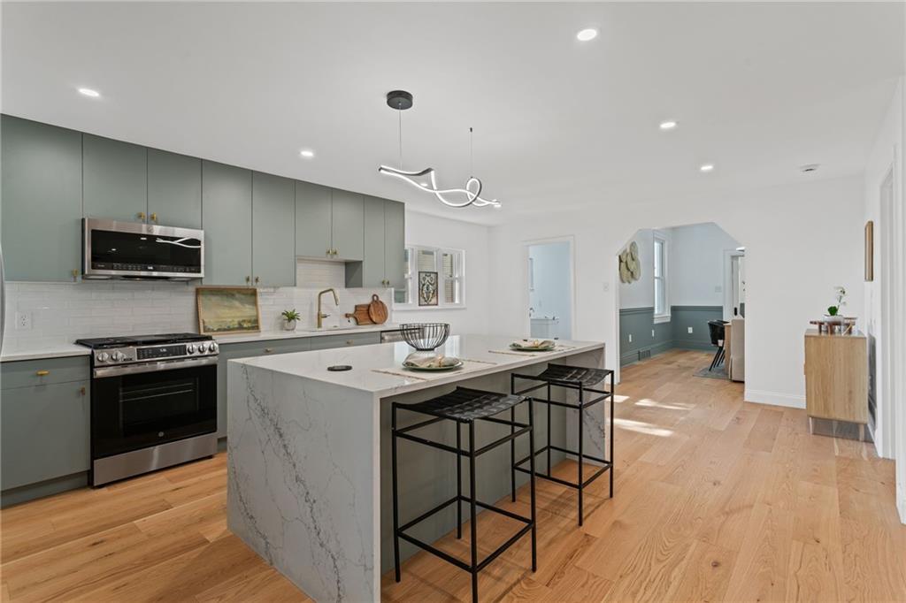 40 Walnut Street Crafton, PA 15205 - Photo 19 of 50 a kitchen with stainless steel appliances kitchen island granite countertop a stove a sink a refrigerator and a microwave