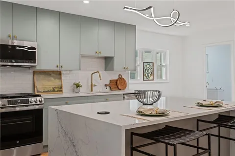 a kitchen with stainless steel appliances a stove a sink and cabinets
