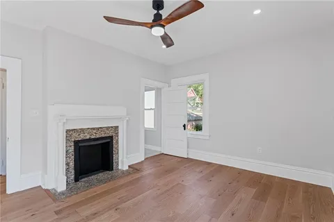 an empty room with windows and fireplace