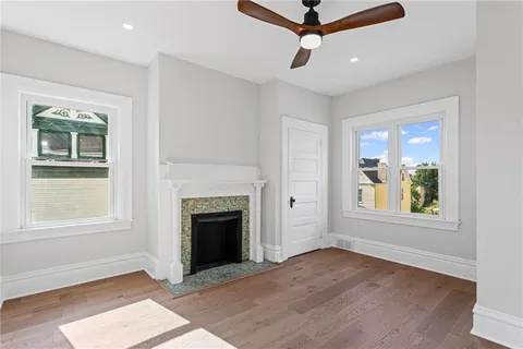 an empty room with windows and fireplace