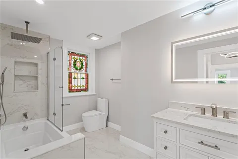 a bathroom with a granite countertop sink a toilet and a mirror