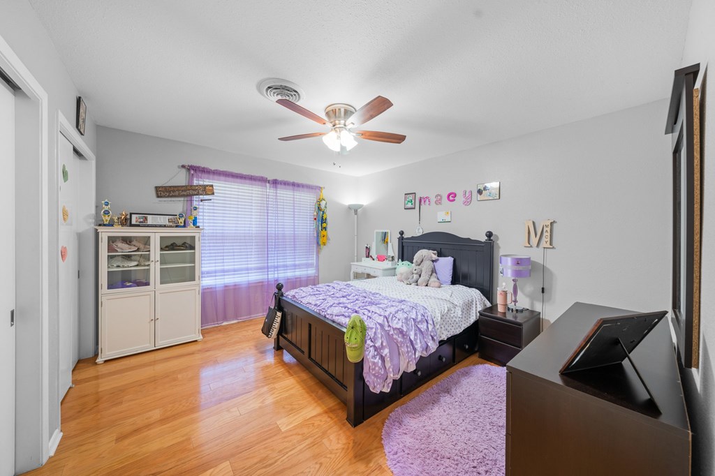 711 Cardinal Drive Kerrville, TX 78028 - Photo 13 of 30 a bedroom with a bed and a chandelier