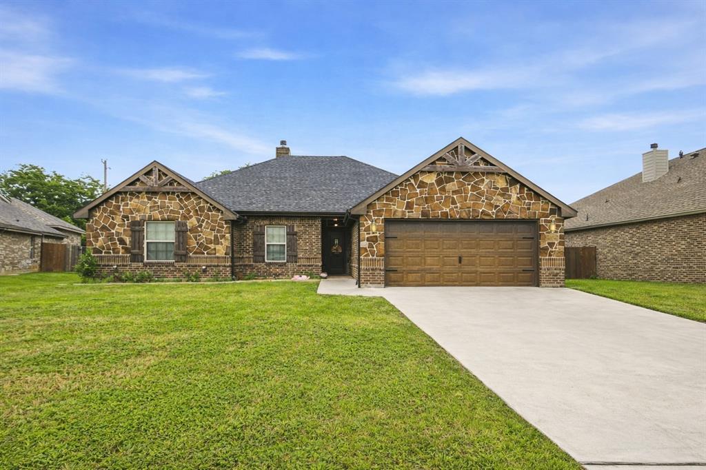 940 Elk Ridge Drive Stephenville, TX 76401 - Photo 1 of 23 a front view of a house with a garden and yard