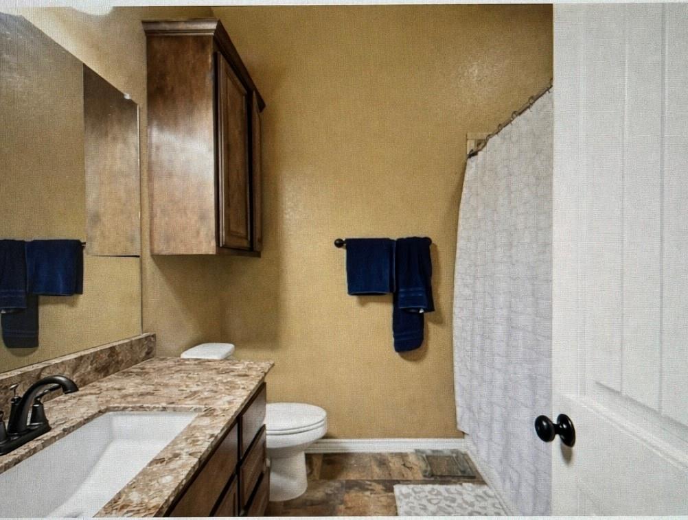 940 Elk Ridge Drive Stephenville, TX 76401 - Photo 18 of 23 a bathroom with a granite countertop sink toilet and shower