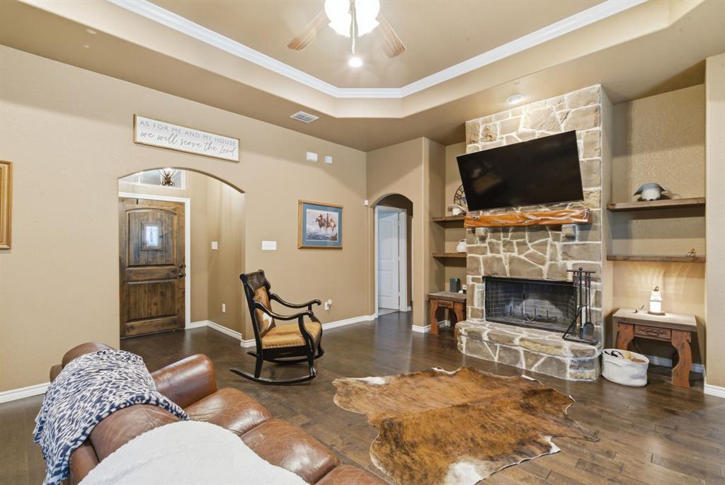 940 Elk Ridge Drive Stephenville, TX 76401 - Photo 4 of 23 a living room with furniture a flat screen tv and a fireplace