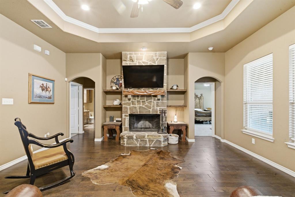 940 Elk Ridge Drive Stephenville, TX 76401 - Photo 5 of 23 a living room with furniture a flat screen tv and a fireplace