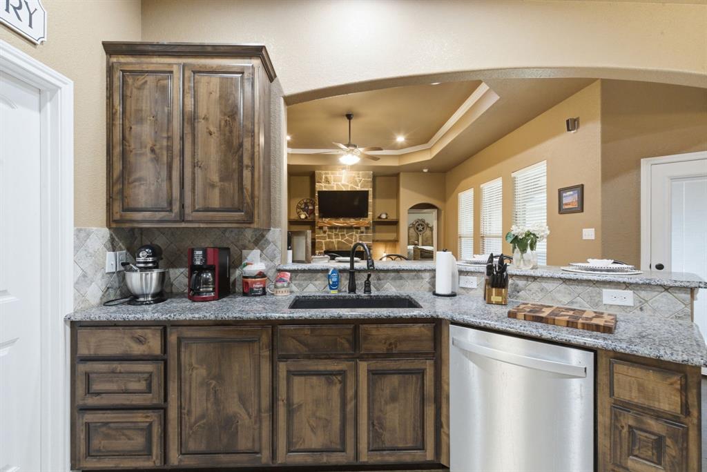940 Elk Ridge Drive Stephenville, TX 76401 - Photo 8 of 23 a kitchen with stainless steel appliances granite countertop a sink stove and cabinets