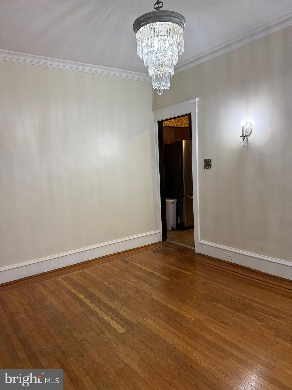 4640 Adams Avenue Philadelphia, PA 19124 - Photo 13 of 34 an empty room with wooden floor and chandelier