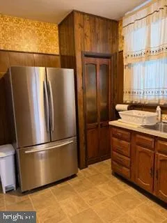 a kitchen with stainless steel appliances granite countertop a refrigerator a sink and a cabinets