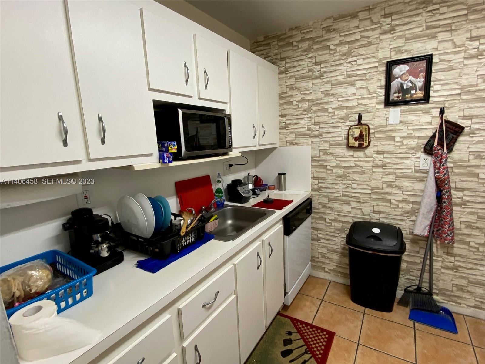 9227 Southwest 87th Avenue, Unit B7 Miami, FL 33176 - Photo 5 of 21 a bathroom with a sink a stove and cabinets
