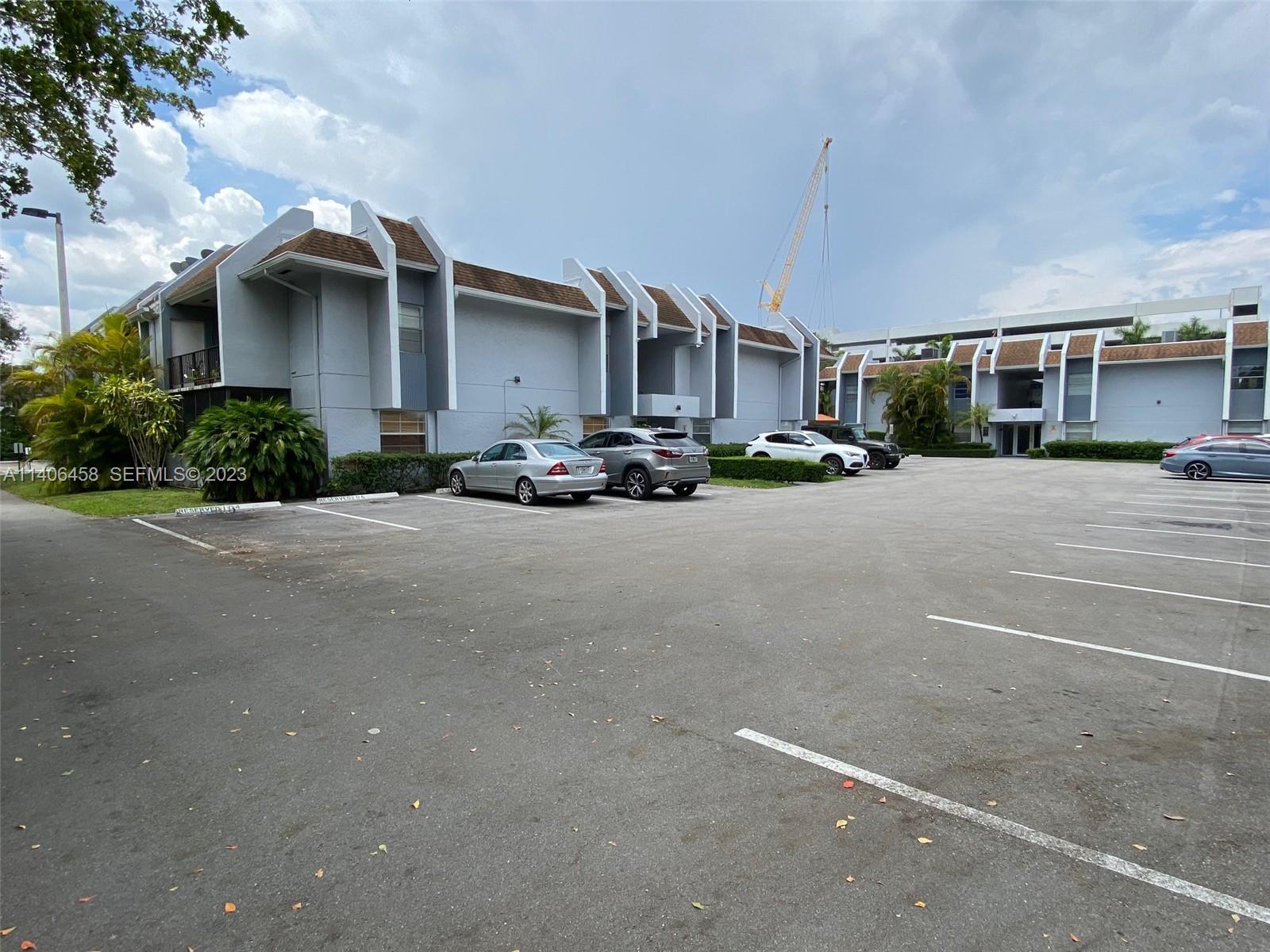 9227 Southwest 87th Avenue, Unit B7 Miami, FL 33176 - Photo 8 of 21 a view of a building with cars parked in front of it