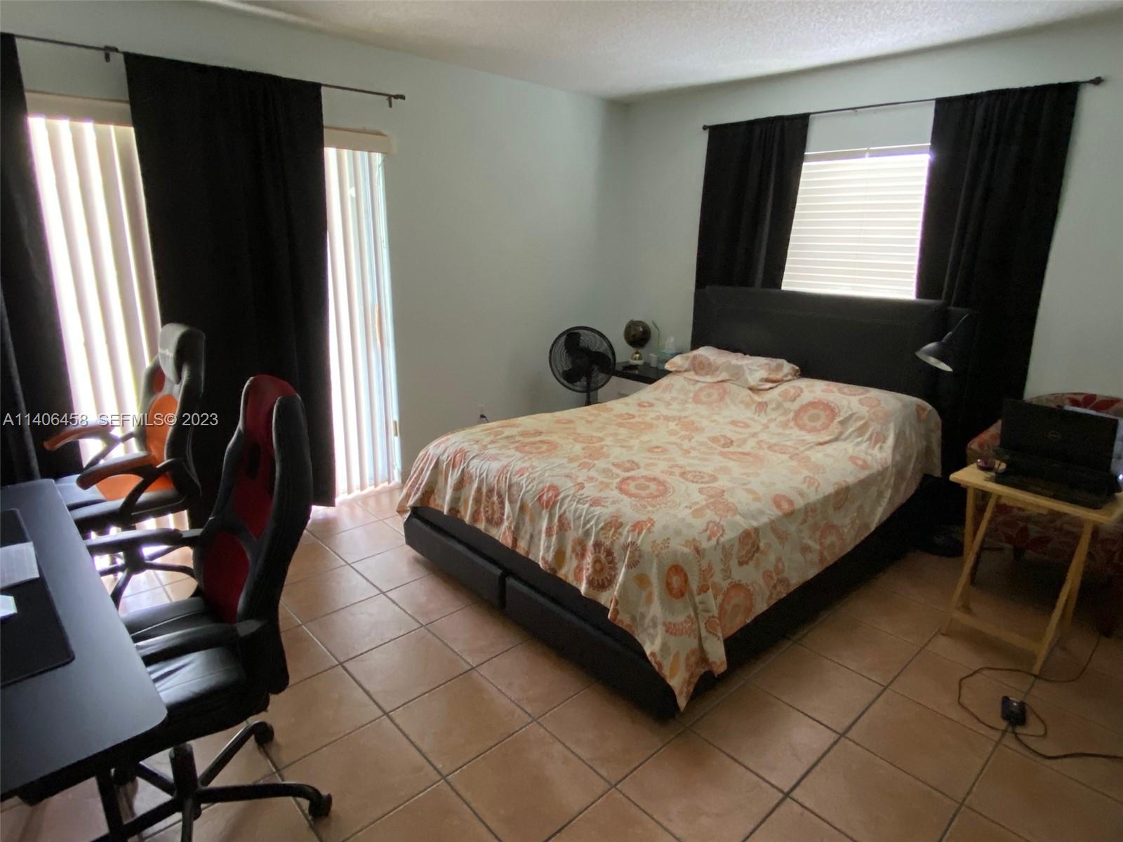 9227 Southwest 87th Avenue, Unit B7 Miami, FL 33176 - Photo 9 of 21 a bedroom with a bed tv and a window