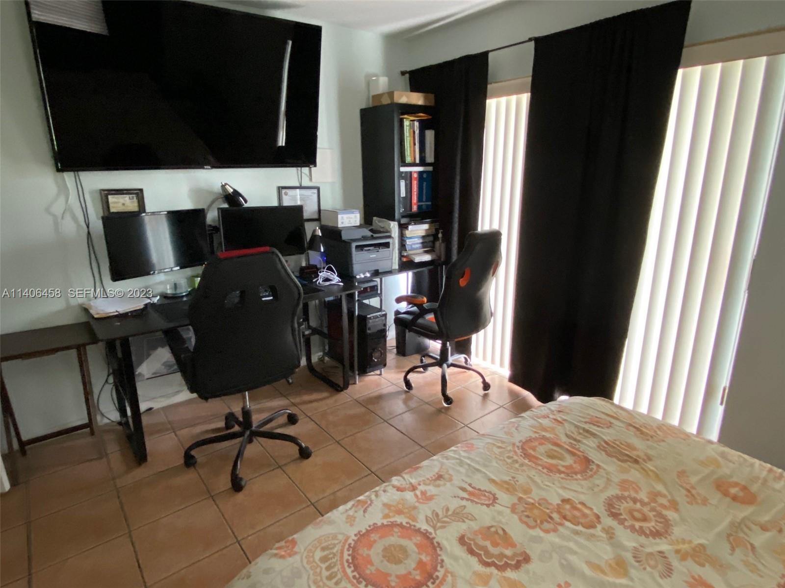 9227 Southwest 87th Avenue, Unit B7 Miami, FL 33176 - Photo 10 of 21 a view of a workspace with furniture and a flat screen tv