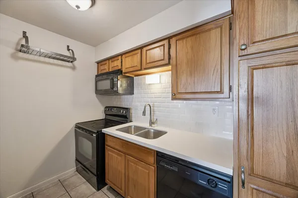 a kitchen with stainless steel appliances granite countertop a sink and a refrigerator