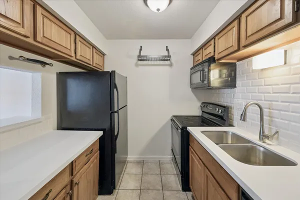 a kitchen with stainless steel appliances granite countertop a sink and a refrigerator