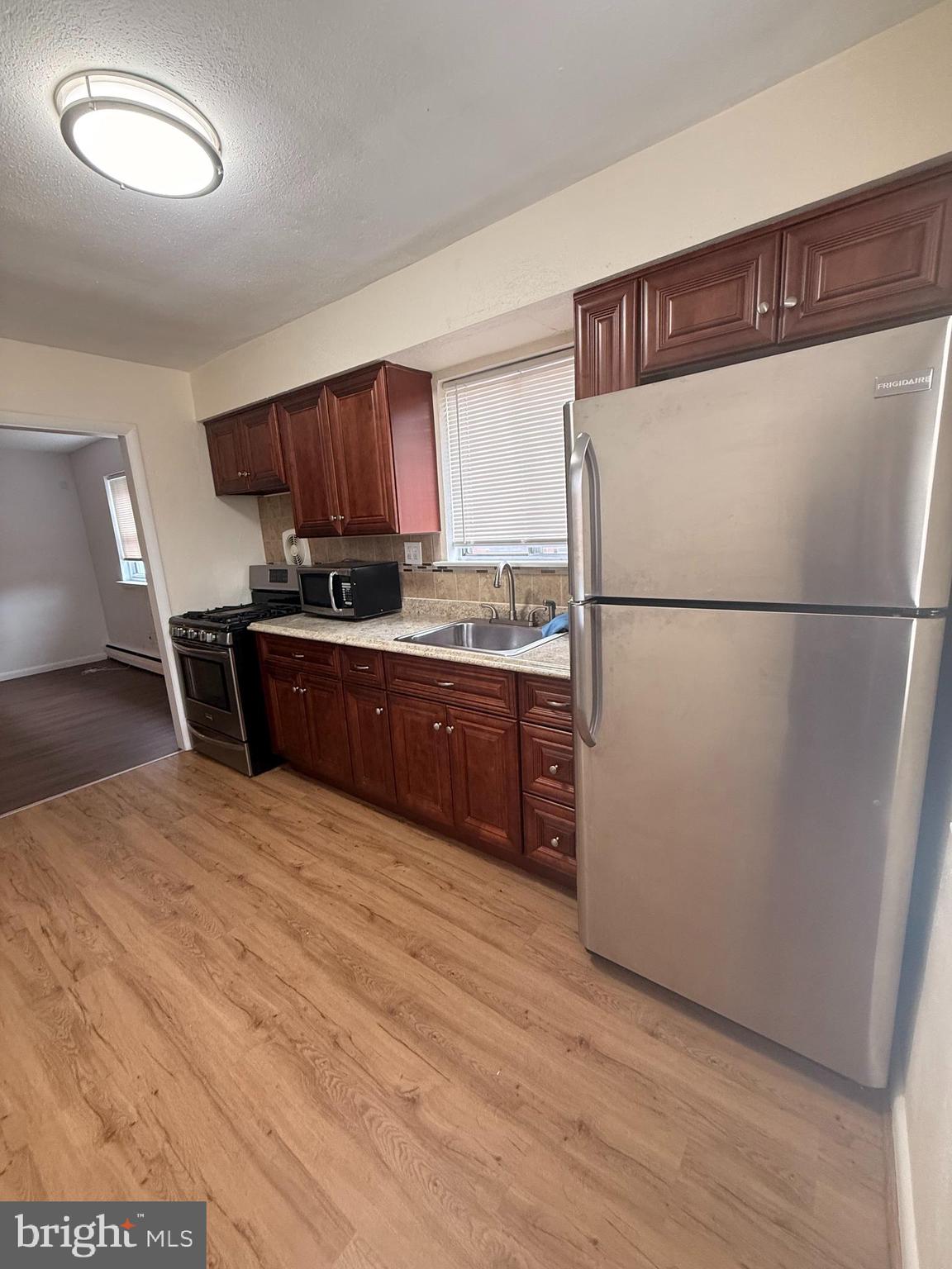 216 Boro Road, Unit A Secane, PA 19018 - Photo 12 of 26 a kitchen with stainless steel appliances granite countertop a refrigerator a sink a stove a microwave a sink and a refrigerator