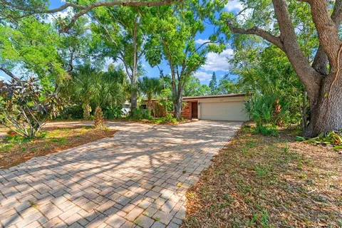 a view of a house with backyard and a tree