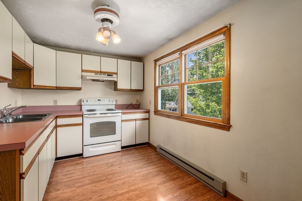 11 Gloucester Road Grafton, MA 01536 - Photo 19 of 38 a kitchen with a white stove top oven sink and cabinets