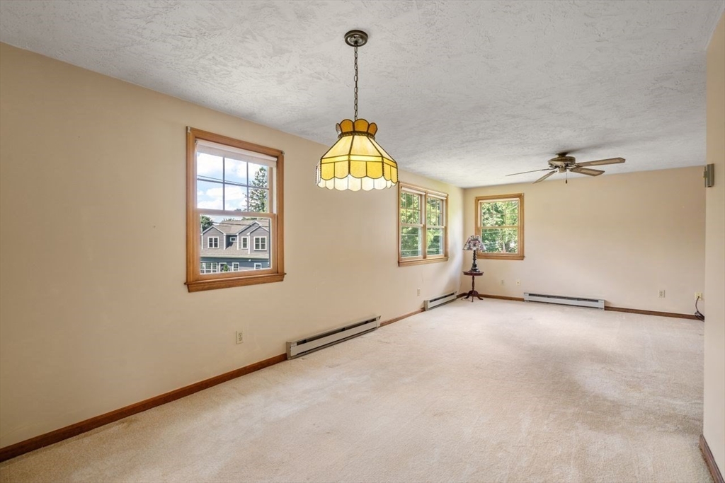 11 Gloucester Road Grafton, MA 01536 - Photo 23 of 38 an empty room with windows and chandelier fan