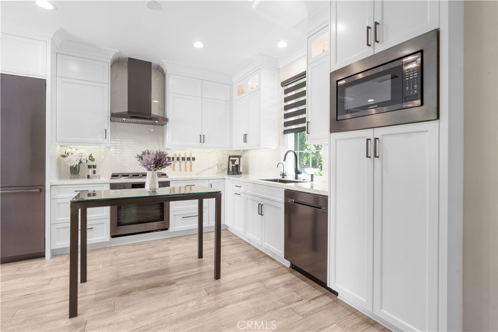 78 Bower Tree Irvine, CA 92603 - Photo 6 of 25 a kitchen with a sink cabinets and stainless steel appliances