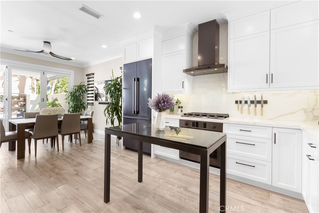 78 Bower Tree Irvine, CA 92603 - Photo 7 of 25 a kitchen with stainless steel appliances a table chairs refrigerator and sink