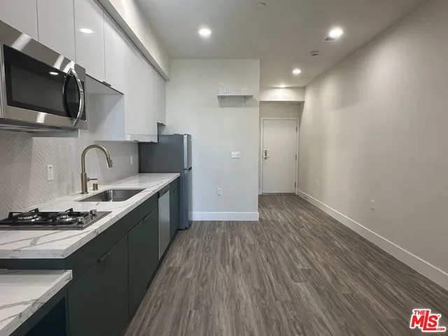 a kitchen with a sink and wooden floor
