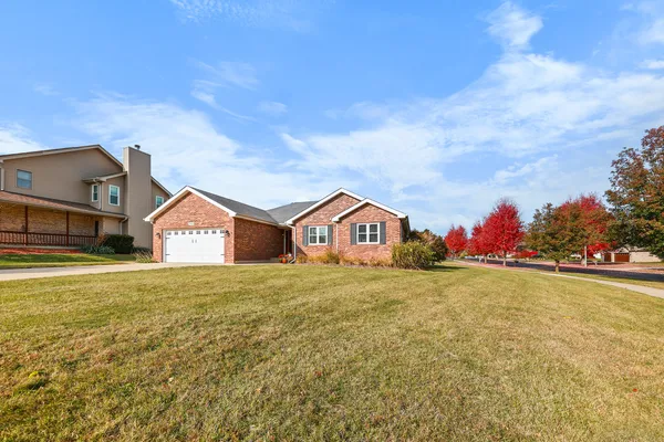 a yellow and red house sitting in middle of a field
