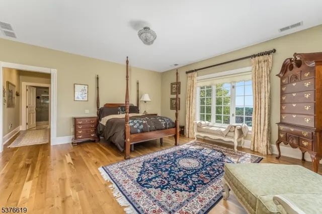 a spacious bedroom with a bed and wooden floor