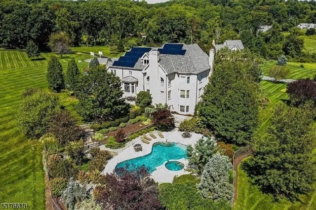 an aerial view of a house with a yard and lake view