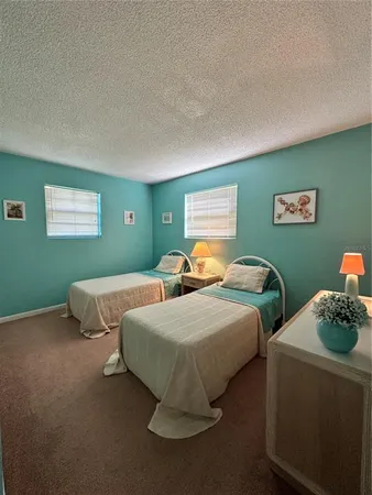 a bedroom with two beds and a chandelier