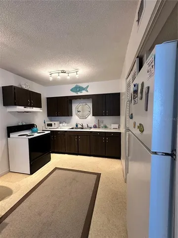 a large kitchen with a large counter top stainless steel appliances and cabinets