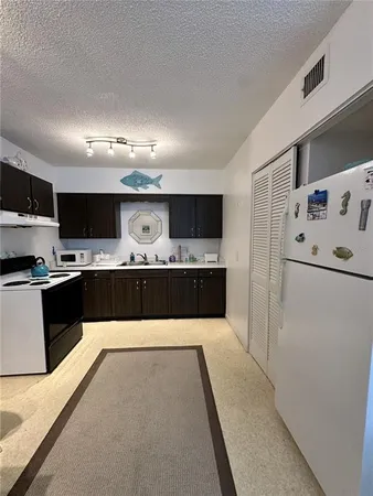 a large kitchen with stainless steel appliances kitchen island a large counter top and a stove top oven