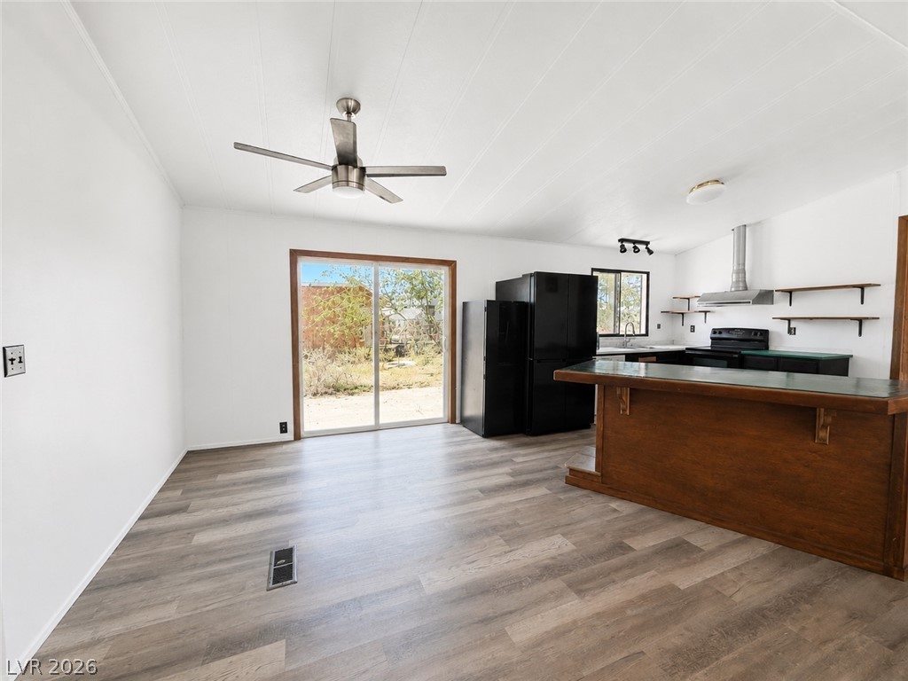 1611 West Blosser Ranch Road Pahrump, NV 89060 - Photo 4 of 25 A combined living and kitchen area features wood-like flooring and outdoor access.