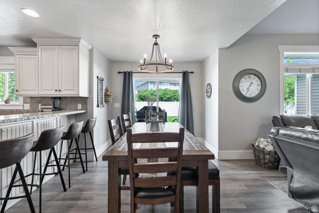 580 Cherry Ridge Lane Richmond, UT 84333 - Photo 11 of 53 Dining space featuring a chandelier, plenty of natural light, dark wood-style floors, and a textured ceiling