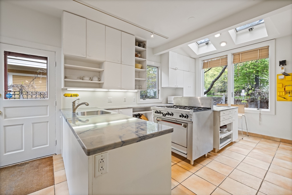 14 Linnaean Street Cambridge, MA 02138 - Photo 2 of 13 a kitchen with granite countertop a sink appliances cabinets and a window