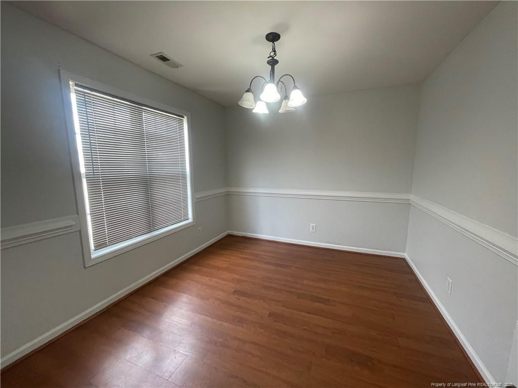 2239 Gray Goose Loop Fayetteville, NC 28306 - Photo 5 of 26 an empty room with wooden floor cabinet and windows
